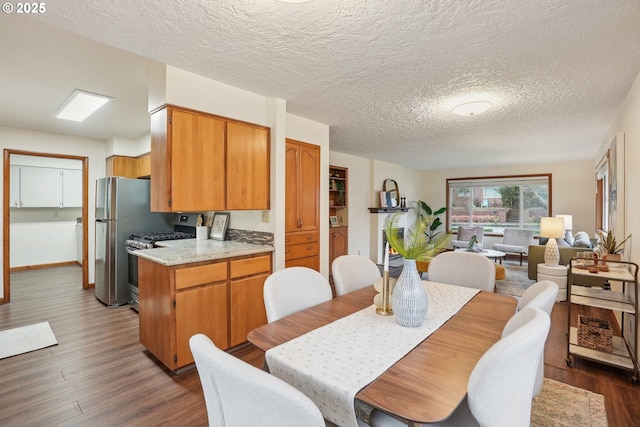 dining space with a textured ceiling and dark hardwood / wood-style floors