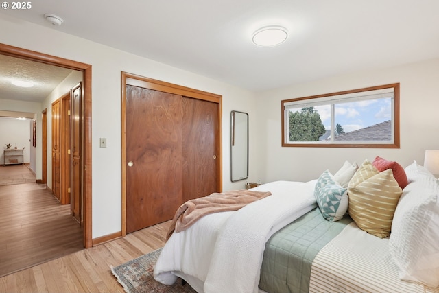 bedroom featuring hardwood / wood-style flooring, a textured ceiling, and a closet