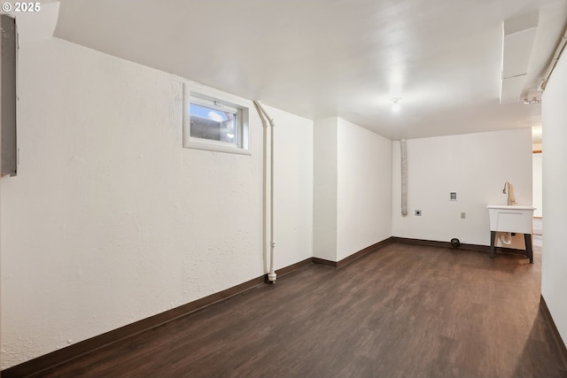 basement featuring sink and dark hardwood / wood-style flooring