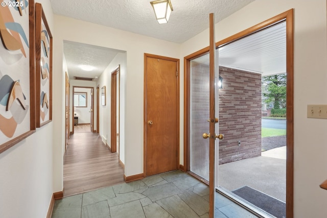 foyer featuring plenty of natural light, french doors, and a textured ceiling