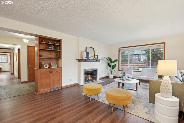 living room with dark wood-type flooring and a textured ceiling