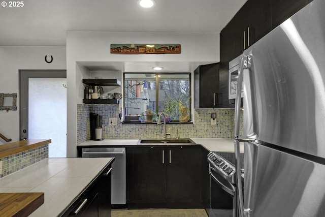 kitchen with dark cabinetry, appliances with stainless steel finishes, and a sink