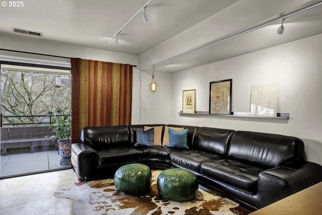 living area with visible vents and rail lighting