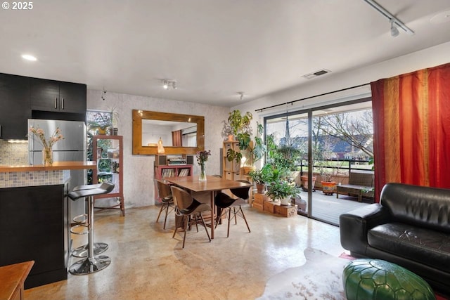 dining area featuring visible vents, finished concrete floors, and track lighting
