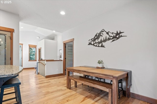 dining area featuring light wood-style flooring, baseboards, vaulted ceiling, and recessed lighting