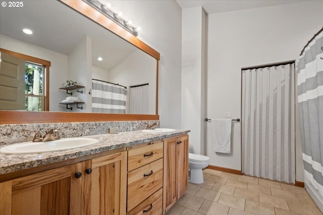 full bathroom with toilet, tile patterned flooring, double vanity, and a sink