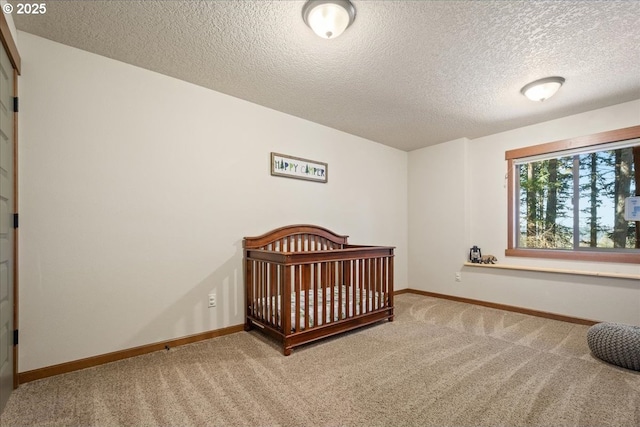 bedroom featuring a textured ceiling, carpet, and baseboards