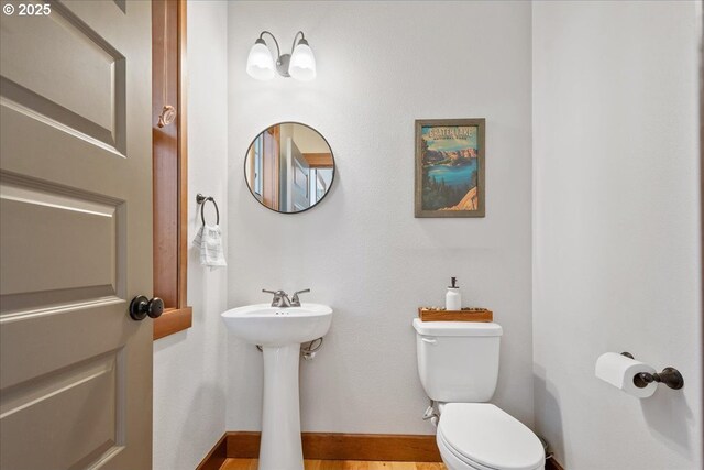 bathroom with toilet and baseboards