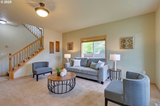 living area featuring baseboards, stairway, and light colored carpet