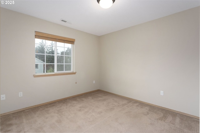 unfurnished room featuring light colored carpet, visible vents, and baseboards