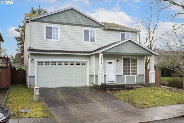 view of front of home with driveway, covered porch, a garage, and fence