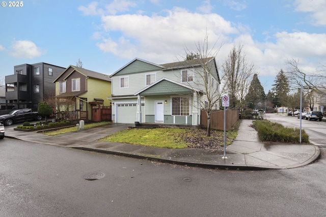 view of front of house featuring a residential view, fence, driveway, and an attached garage