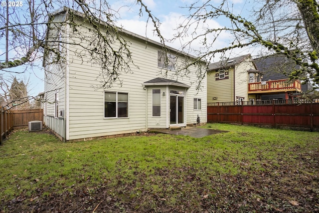 back of house with a fenced backyard, a patio, a lawn, and central air condition unit