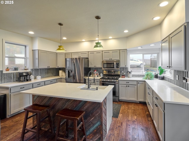 23860 S Beavercreek Rd, Beavercreek, OR 97004 - kitchen with stainless steel appliances, tasteful backsplash, gray cabinets, a kitchen bar, and recessed lighting