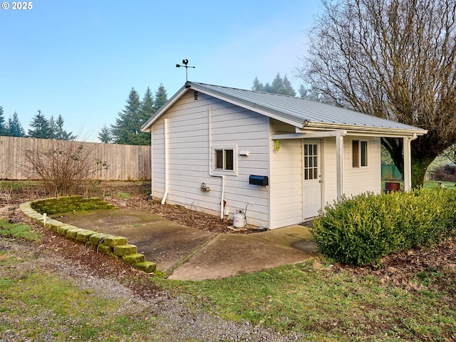 view of home's exterior featuring a patio area, fence, and metal roof