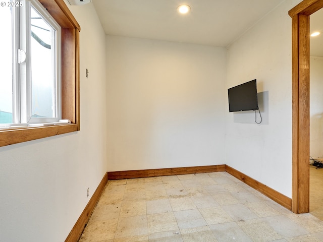 spare room with recessed lighting and baseboards