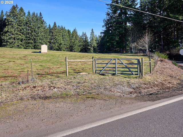 view of gate with a yard and fence