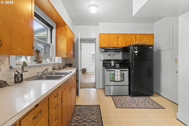 1937 SE Knight St, Portland, OR 97202 - kitchen with stainless steel range with electric cooktop, freestanding refrigerator, under cabinet range hood, a sink, and brown cabinets
