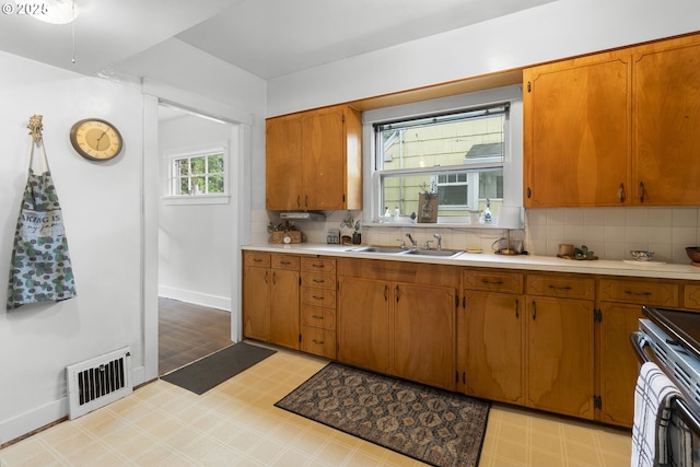 1937 SE Knight St, Portland, OR 97202 - kitchen featuring light floors, a sink, light countertops, and decorative backsplash