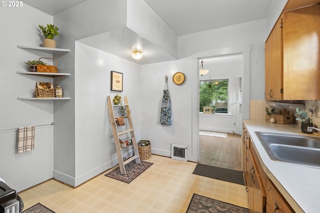1937 SE Knight St, Portland, OR 97202 - kitchen featuring brown cabinetry, light countertops, open shelves, and light floors