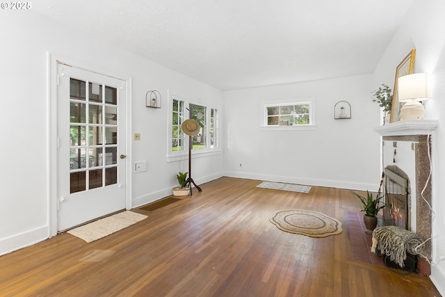 1937 SE Knight St, Portland, OR 97202 - entryway featuring wood finished floors, baseboards, and a lit fireplace