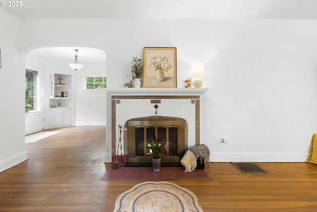 1937 SE Knight St, Portland, OR 97202 - living room with a fireplace, baseboards, arched walkways, wood finished floors, and built in features