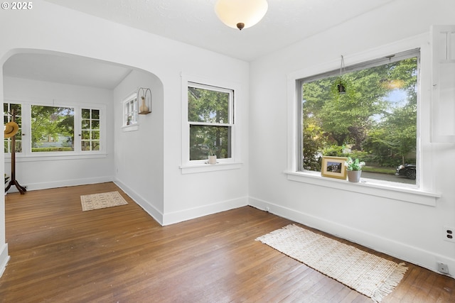 1937 SE Knight St, Portland, OR 97202 - spare room featuring arched walkways, wood-type flooring, and baseboards