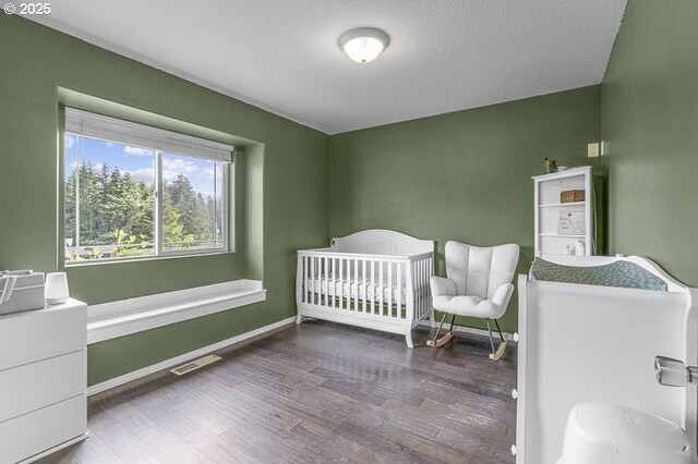 11364 James Way Dr SE, Aumsville, OR 97325 - bedroom featuring wood finished floors, baseboards, and a nursery area