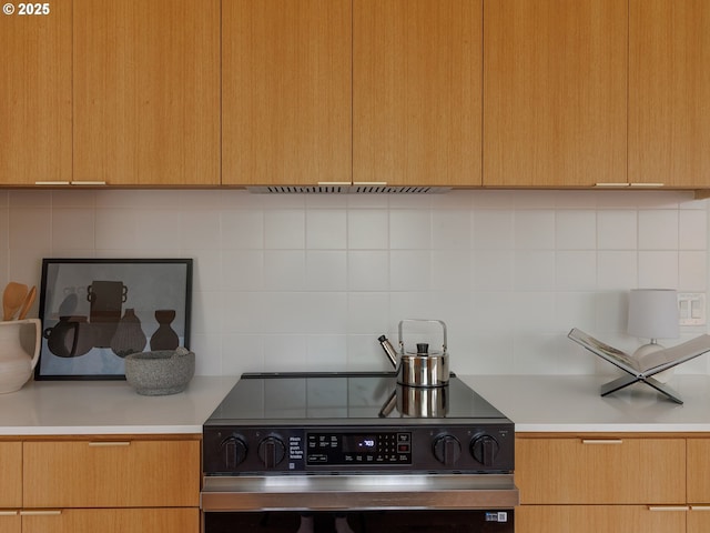 kitchen with light countertops, stainless steel range with electric cooktop, decorative backsplash, and modern cabinets