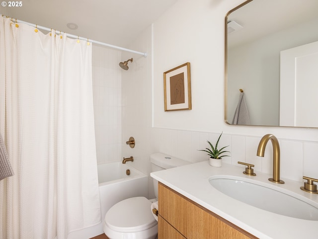 bathroom featuring wainscoting, toilet, shower / bathtub combination with curtain, and vanity