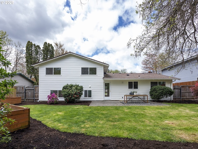back of house featuring a yard, a patio, fence, and a garden