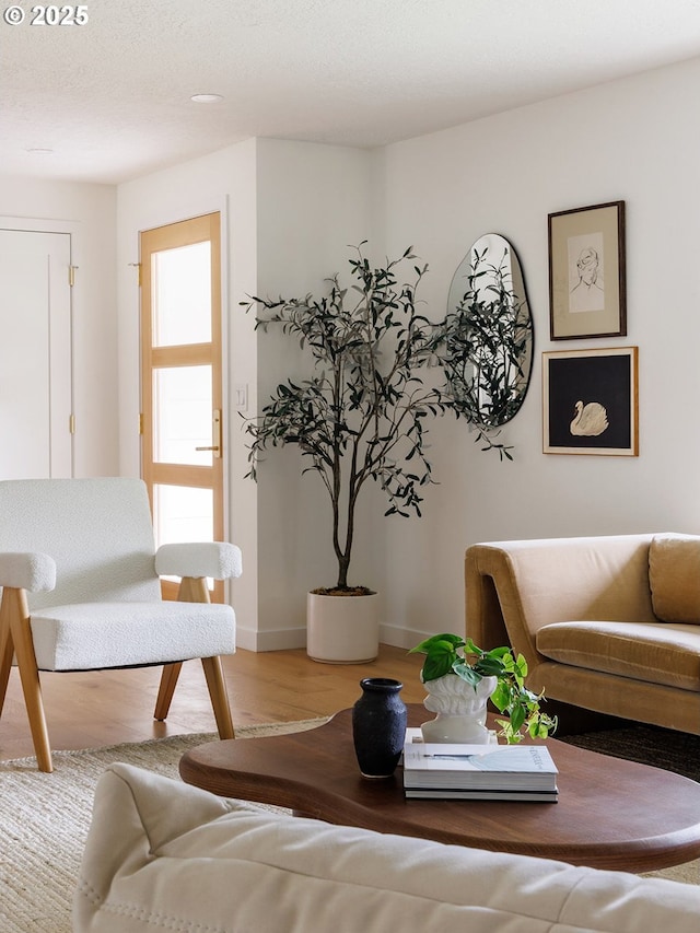 living area with baseboards and wood finished floors