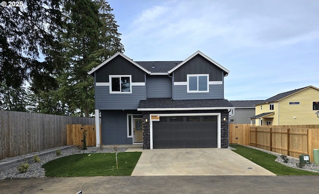 view of front facade with concrete driveway, a garage, fence private yard, and board and batten siding