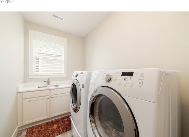 clothes washing area featuring cabinet space, visible vents, washer and dryer, and a sink