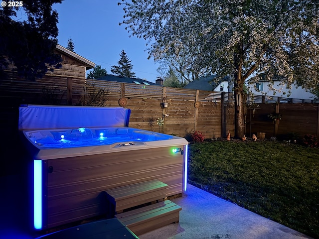 view of patio / terrace with fence and a hot tub