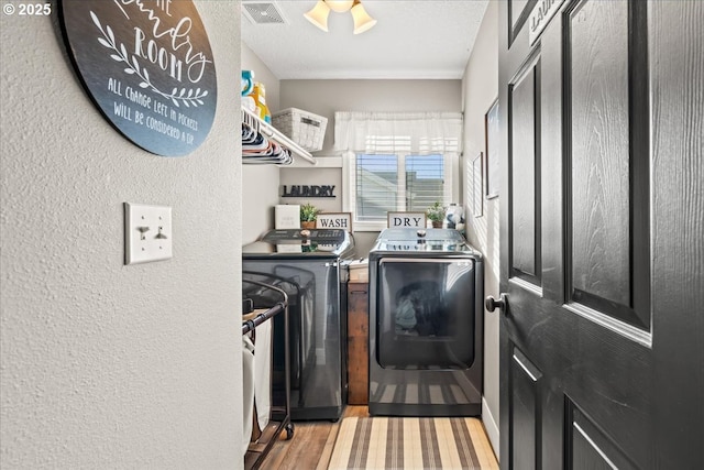 laundry room featuring independent washer and dryer and light hardwood / wood-style floors