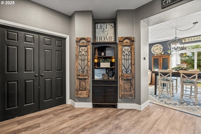 interior space with a chandelier and light hardwood / wood-style flooring