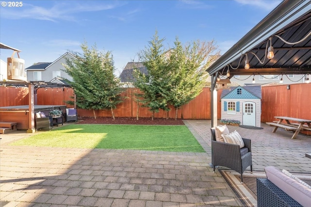 view of patio with an outbuilding, a hot tub, and outdoor lounge area