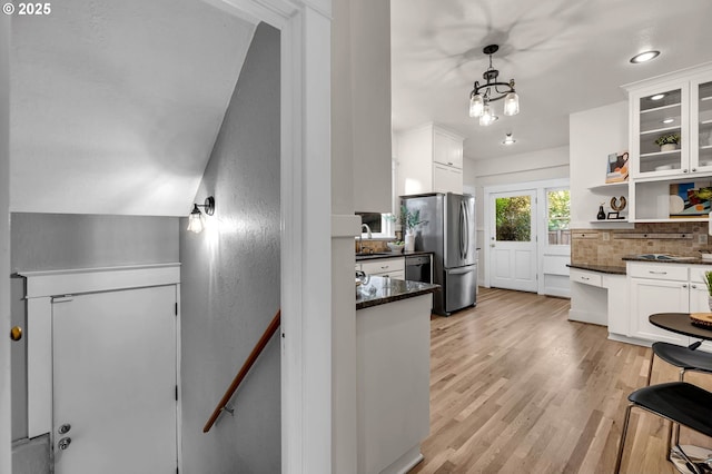3136 NE 41st Ave, Portland, OR 97212 - kitchen with white cabinets, backsplash, freestanding refrigerator, light wood-style floors, and glass insert cabinets