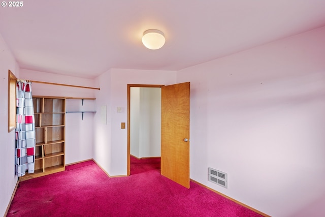 unfurnished bedroom featuring a closet, carpet, and visible vents