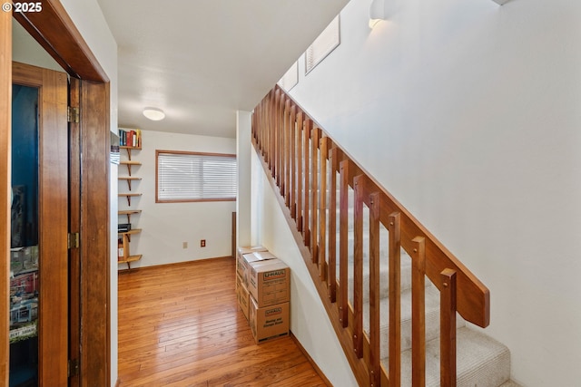 stairway with wood-type flooring and baseboards