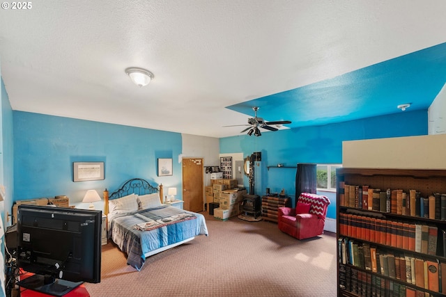 bedroom with a textured ceiling, carpet, and a ceiling fan