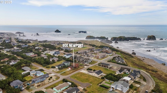 drone / aerial view featuring a water view, a residential view, and a view of the beach