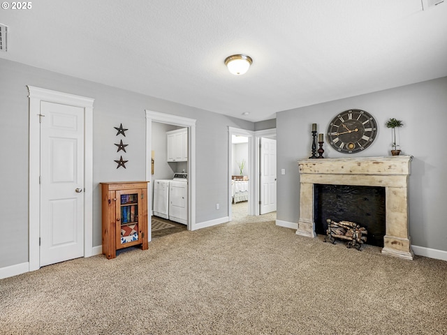 living area featuring washing machine and dryer, a fireplace, and carpet flooring