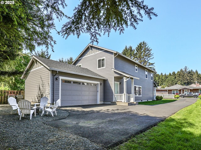 view of front of home with fence, asphalt driveway, an attached garage, and board and batten siding