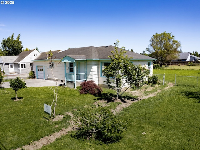 rear view of property featuring a garage and a lawn