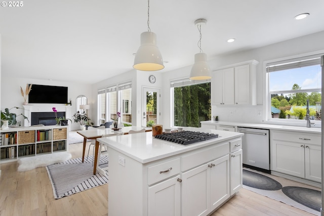 21890 SW 106th Ave, Tualatin, OR 97062 - kitchen with stainless steel appliances, open floor plan, light countertops, light wood-type flooring, and a kitchen island