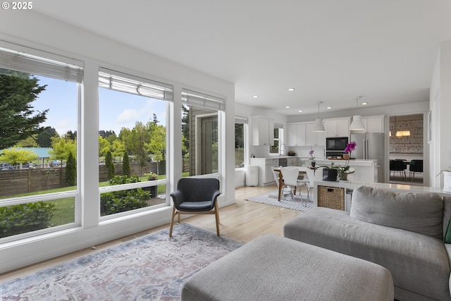 living area featuring recessed lighting, a wealth of natural light, and light wood-style flooring