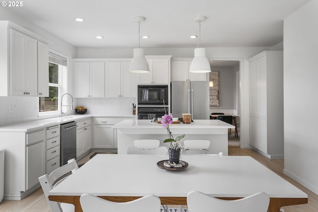 21890 SW 106th Ave, Tualatin, OR 97062 - kitchen with black appliances, a sink, a kitchen island, white cabinets, and recessed lighting