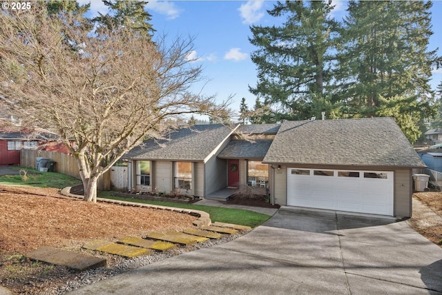 view of front of house featuring a garage, a shingled roof, and fence